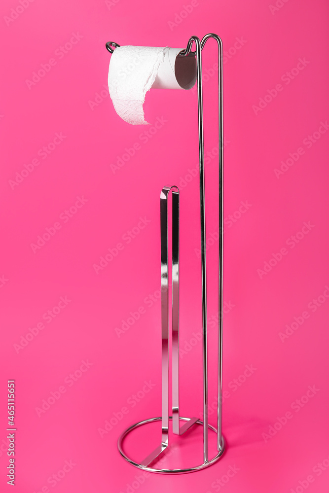 Holder with cardboard tube for toilet paper on color background