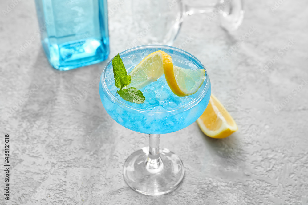 Glass of Blue Lagoon cocktail on light background, closeup