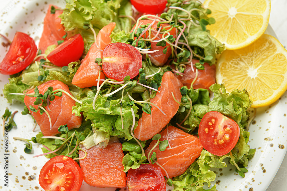 Tasty fresh salad with salmon in plate, closeup