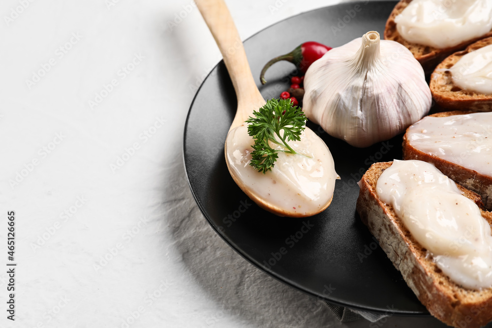 Plate of bread with lard spread on white background, closeup