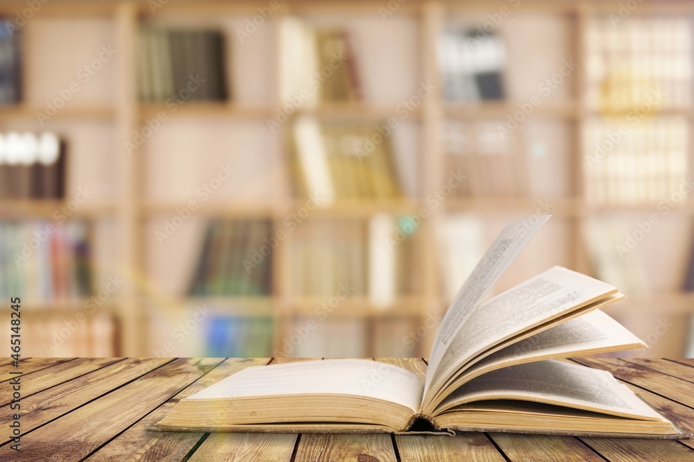 Open book on old wooden table in the library