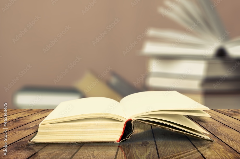 Open book on old wooden table in the library