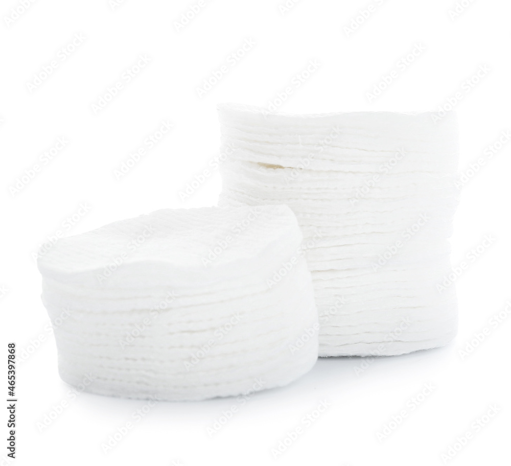 Stacks of new cotton pads on white background