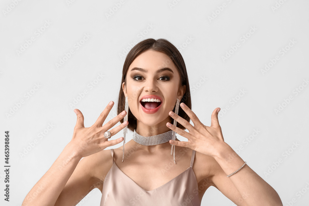 Happy woman with beautiful manicure and trendy jewelry on white background