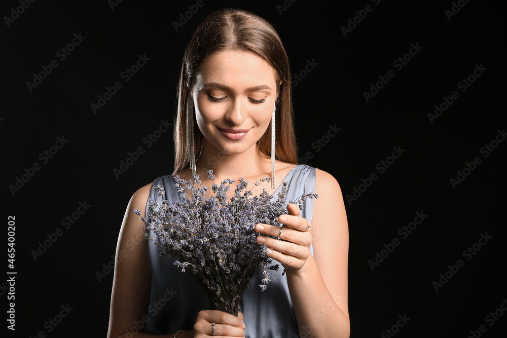 美丽的年轻女子，黑色背景上有一束薰衣草