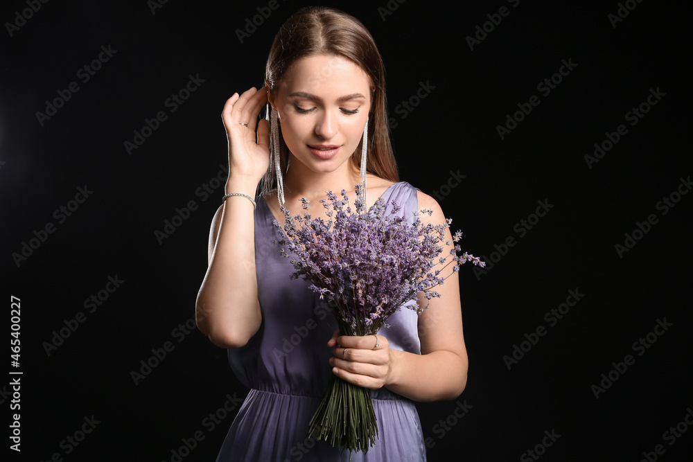 美丽的年轻女子，黑色背景上有一束薰衣草