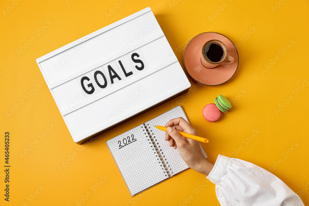 Woman with notebook making to do list for 2022 year