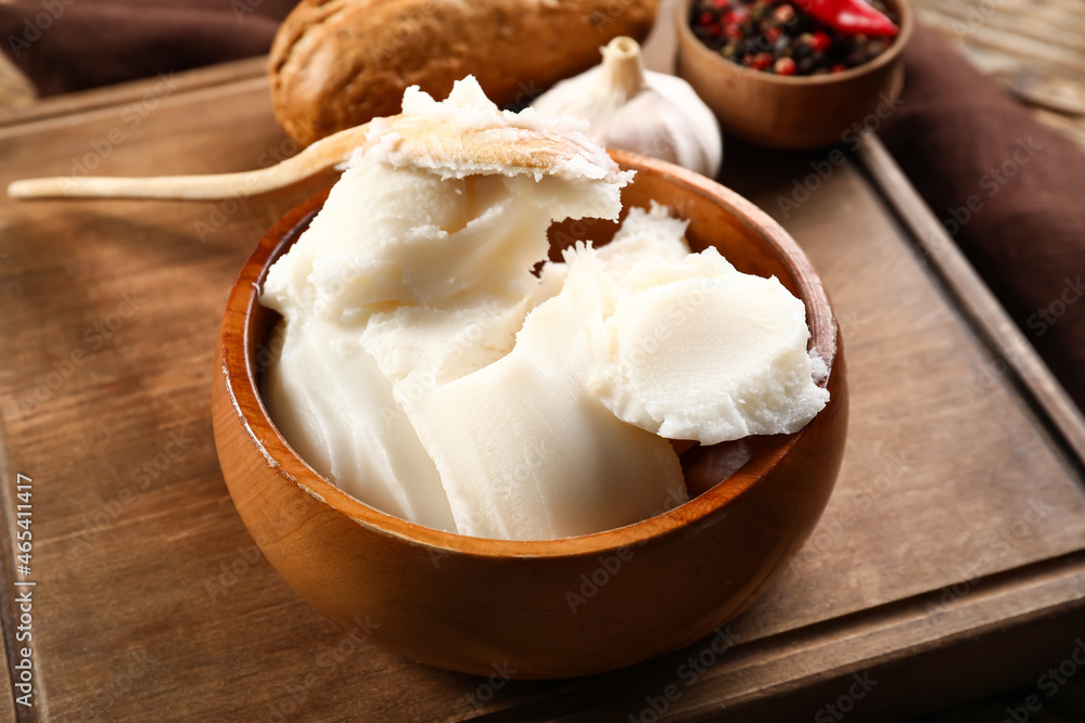 Bowl of lard spread on wooden background