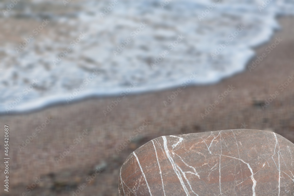 Stone rocky pedestal or podium in front of sea ocean beach background.