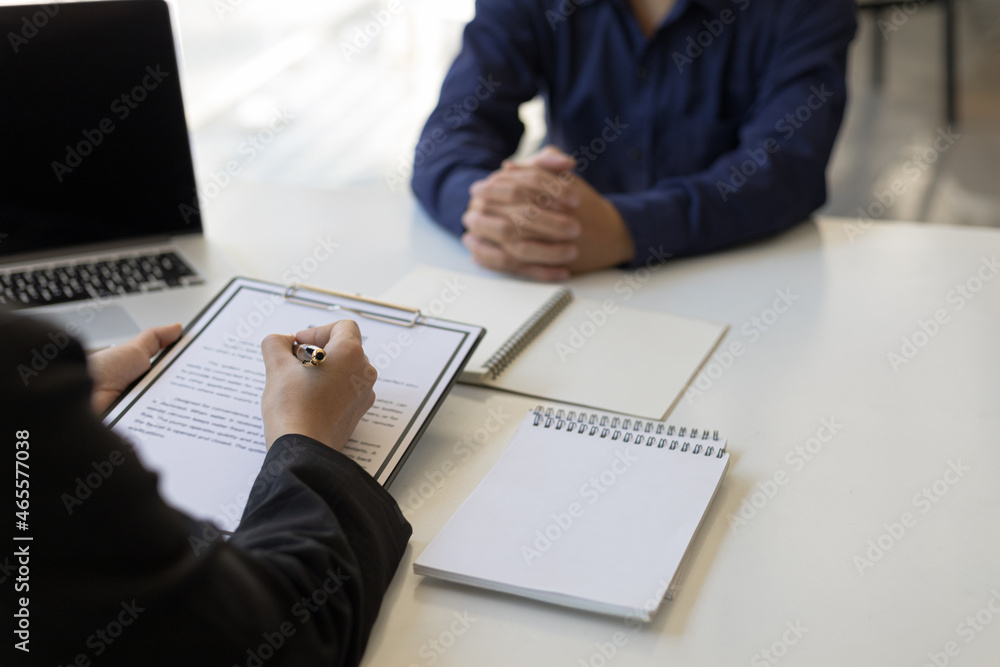 The manager holds a resume and is interviewing new employees.