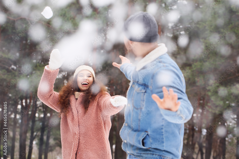 快乐的年轻夫妇在冬日的森林里玩得很开心