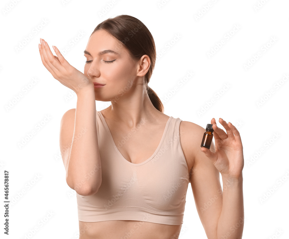 Woman smelling essential oil on white background