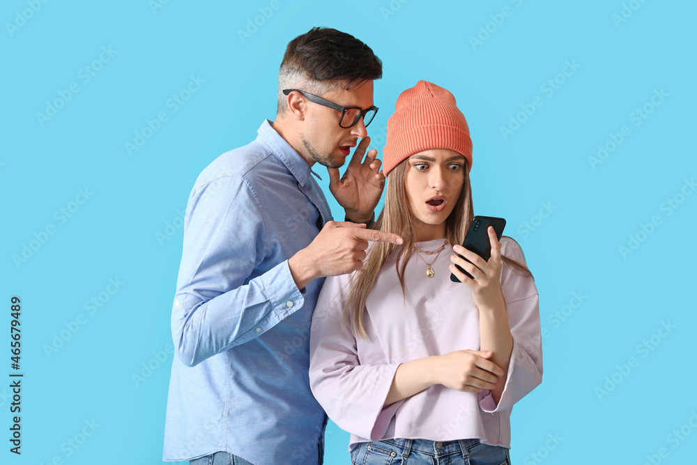 Gossiping people with phone on color background