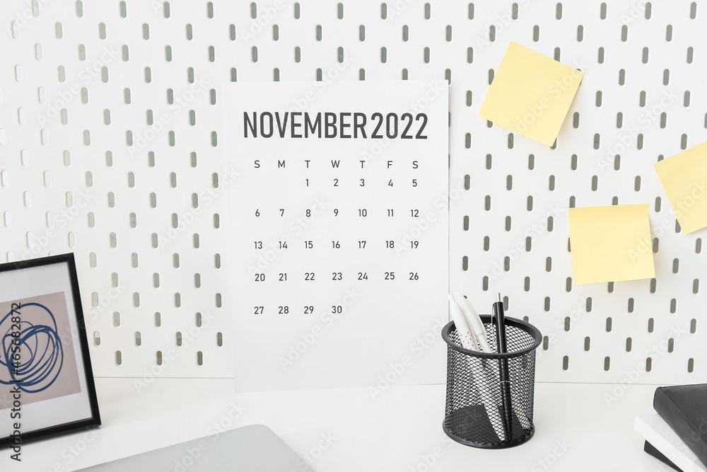 Calendar page of November 2022 and stationery on table. Black Friday