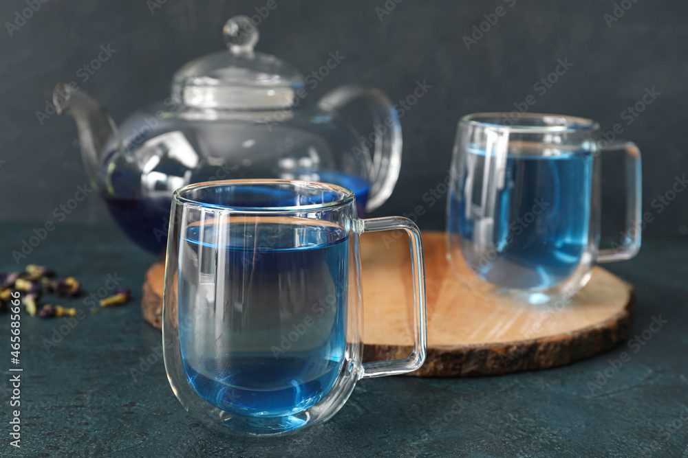 Cups of blue tea on dark background