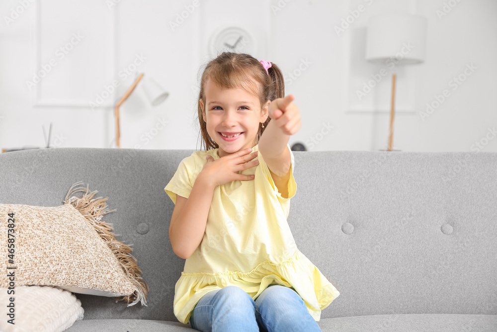 Happy little girl watching TV at home