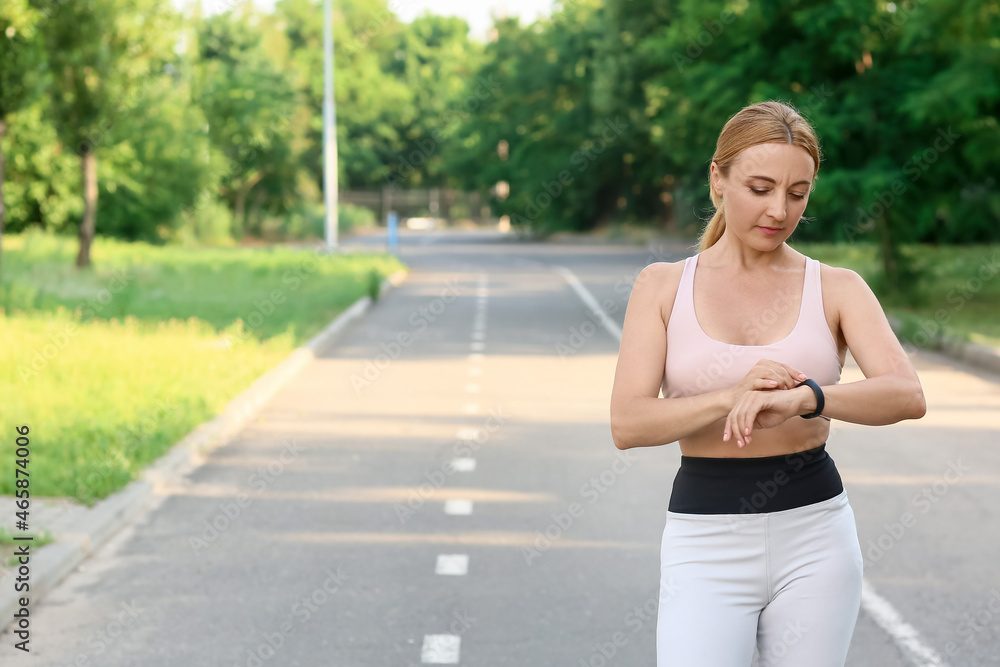 女性跑步者户外检查脉搏