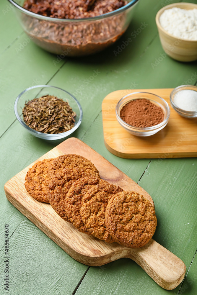 Board with tasty hojicha cookies on green wooden background