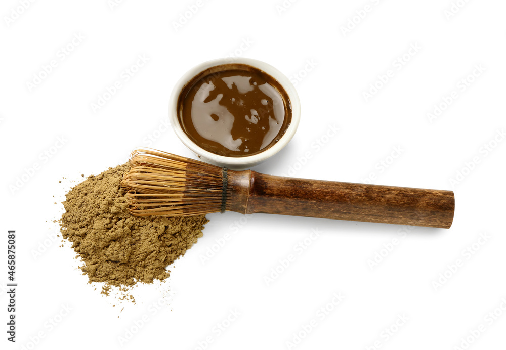 Bowl with hojicha green tea, powder and chasen on white background