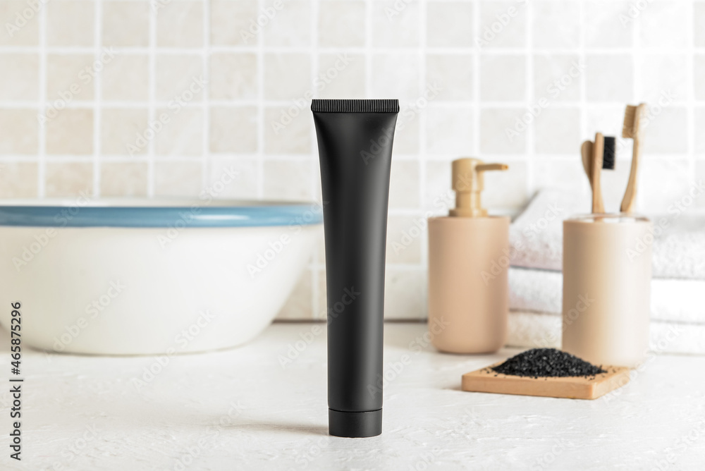 Black toothpaste with activated carbon on table in bathroom