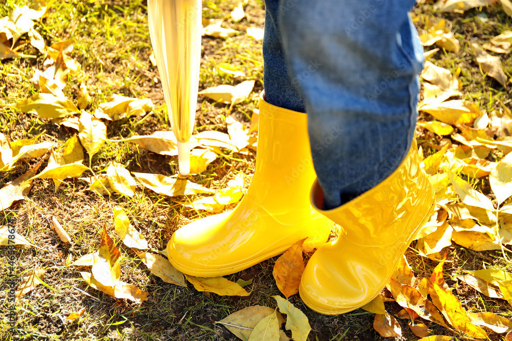 Young woman in gumboots outdoors on autumn day