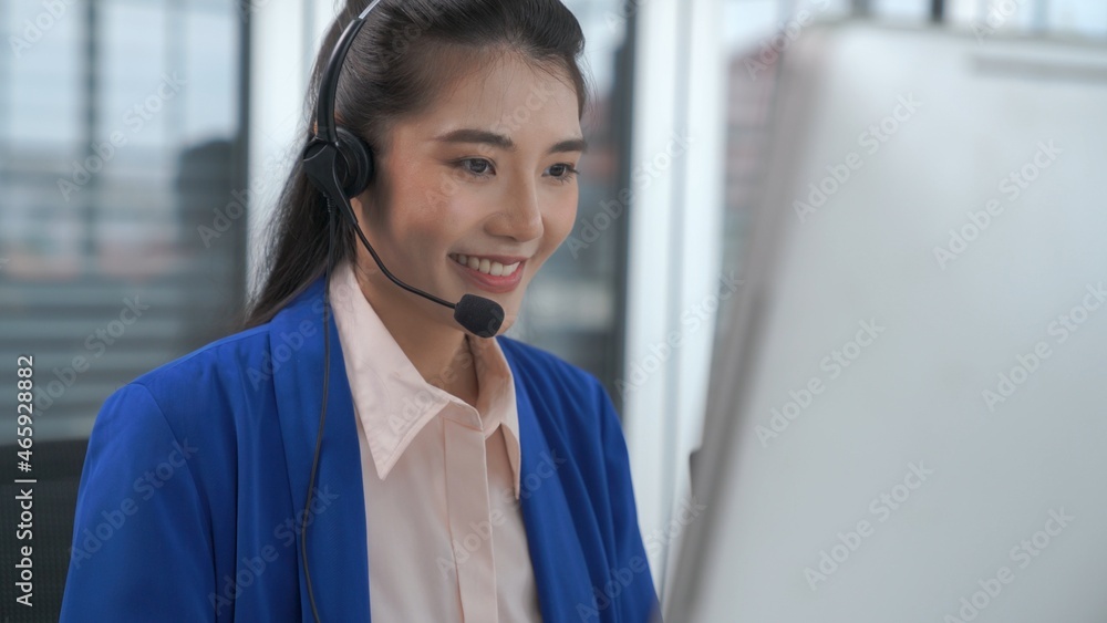 Businesswoman wearing headset working actively in office . Call center, telemarketing, customer supp