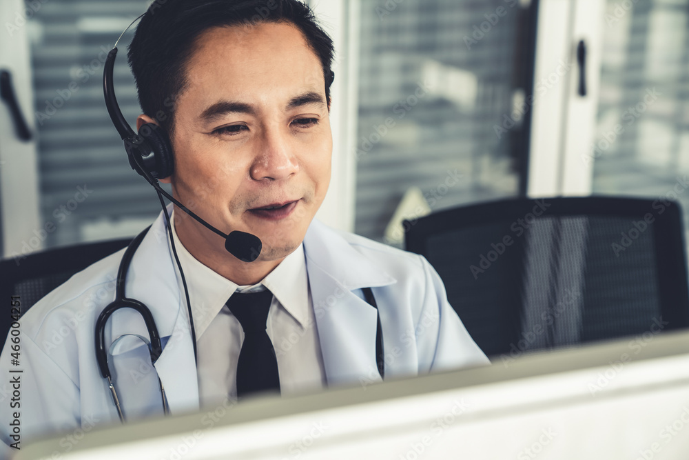 Doctor wearing headset talking actively on video call in a clinic or hospital . Concept of telehealt