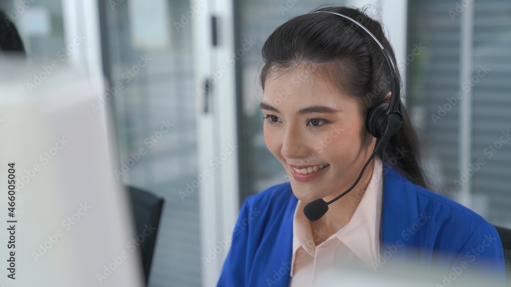 Businesswoman wearing headset working actively in office . Call center, telemarketing, customer supp