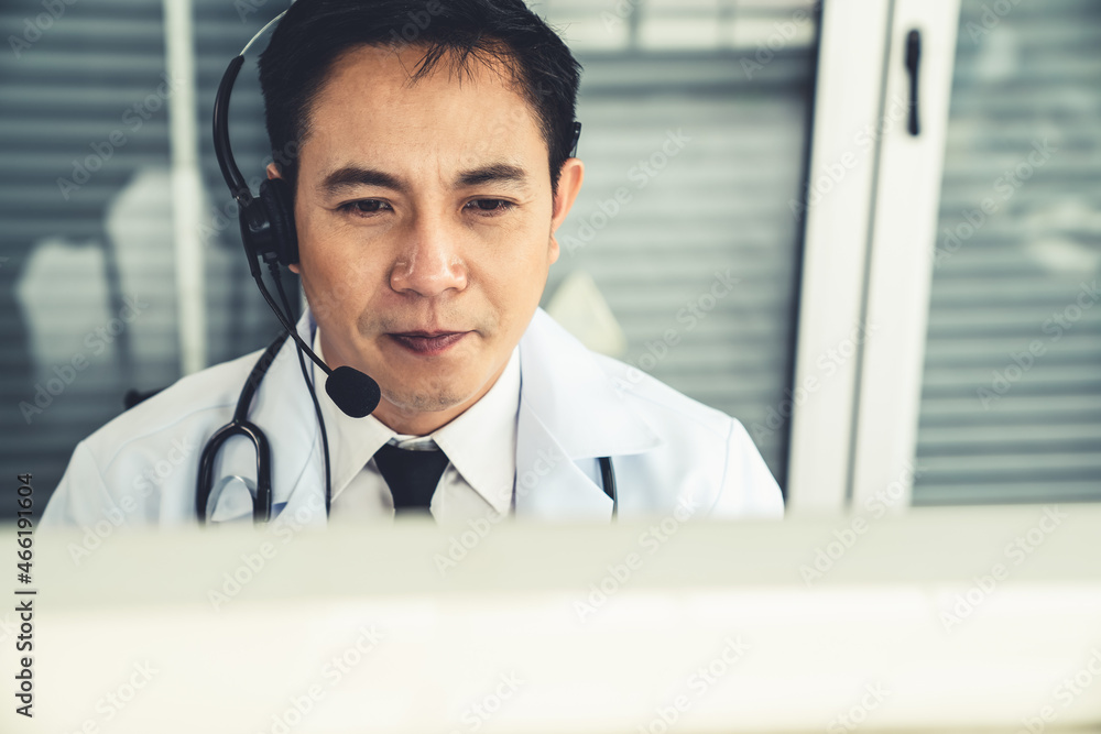 Doctor wearing headset talking actively on video call in a clinic or hospital . Concept of telehealt