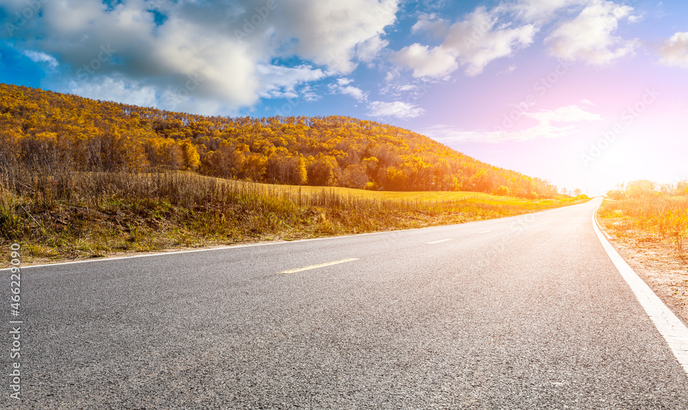 Asphalt road and mountain nature landscape at sunrise.Road and mountain with trees scenery in autumn