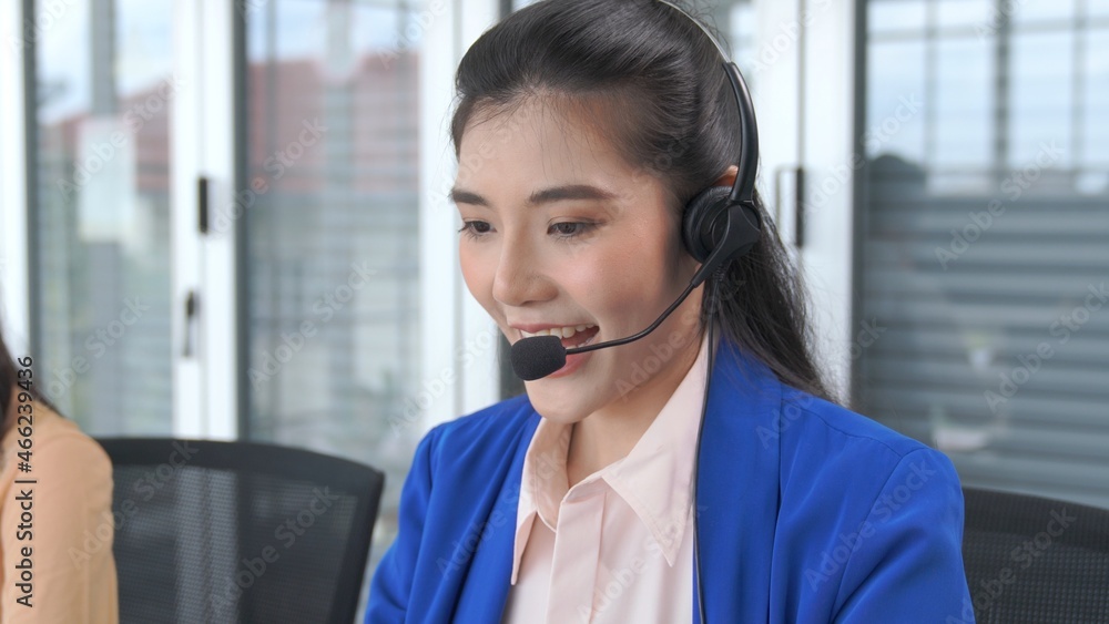 Businesswoman wearing headset working actively in office . Call center, telemarketing, customer supp