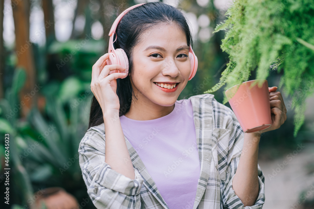 年轻的亚洲女人在花园里喝茶