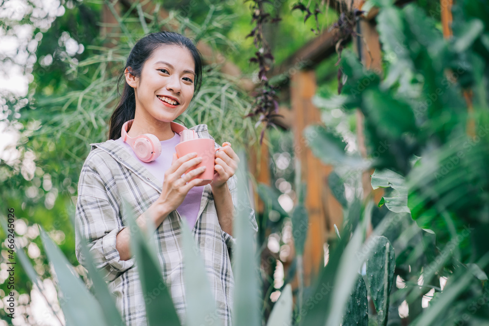 Young Asian woman drinking tea in the garden