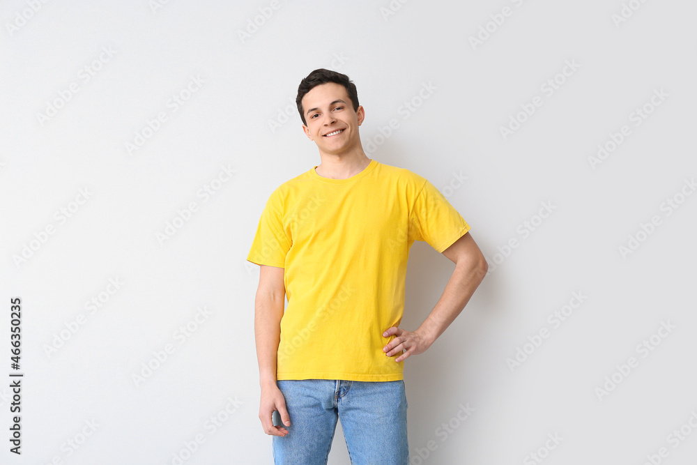 Handsome young man in stylish t-shirt on light background