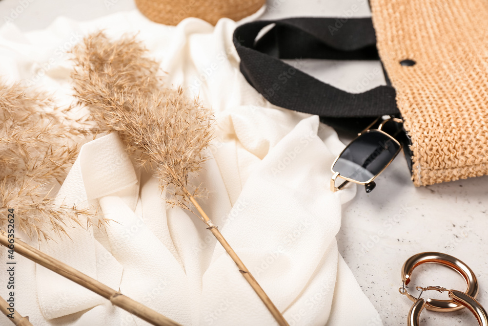 Dry reeds and stylish female accessories on light background, closeup