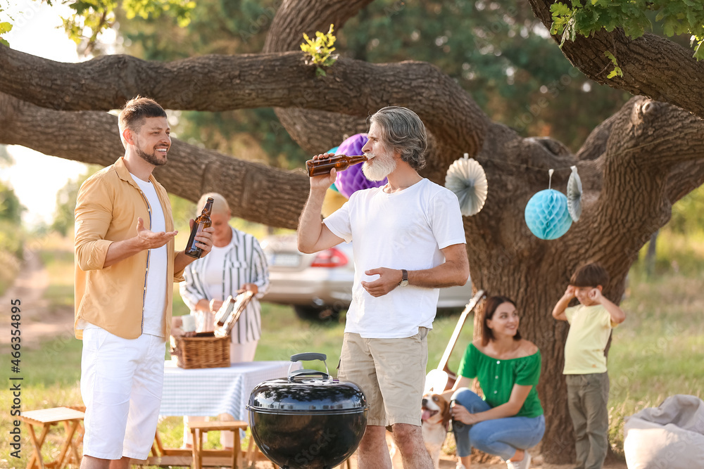 Happy family at barbecue party on summer day