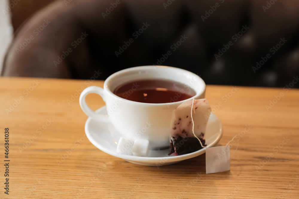 Cup with tea bag and sugar on table in cafe, closeup