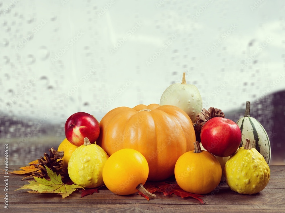 Autumn cozy mood composition on the windowsill. Pumpkins, dried leaves on the desk