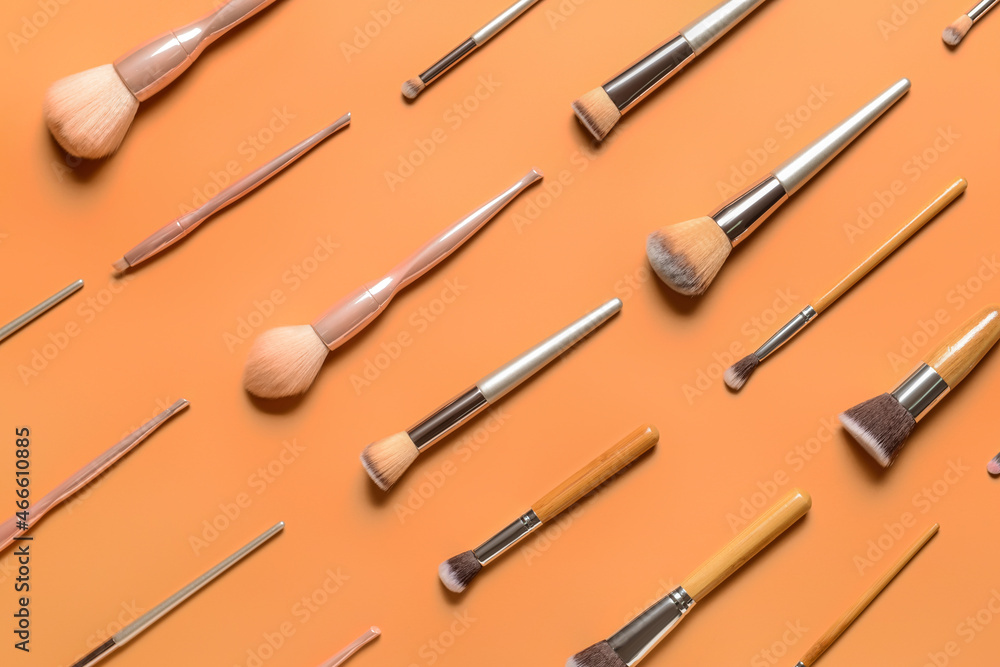 Set of professional makeup brushes on color background