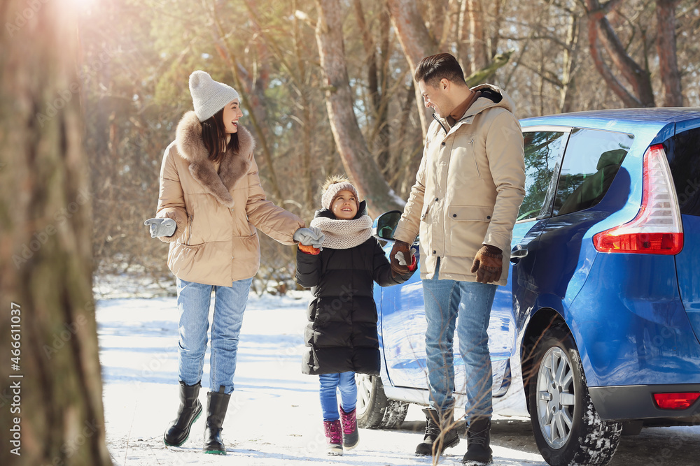 Happy family walking in forest on winter day