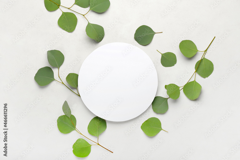 Blank paper card and eucalyptus branches on light background