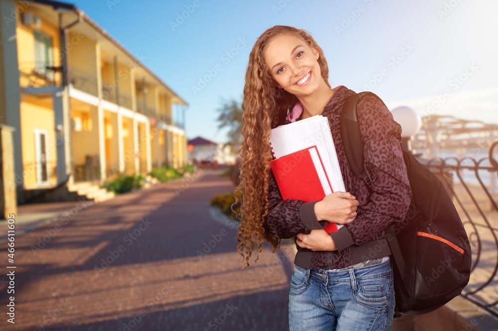 快乐的学生女孩背着背包摆姿势。现代教育与学生生活方式