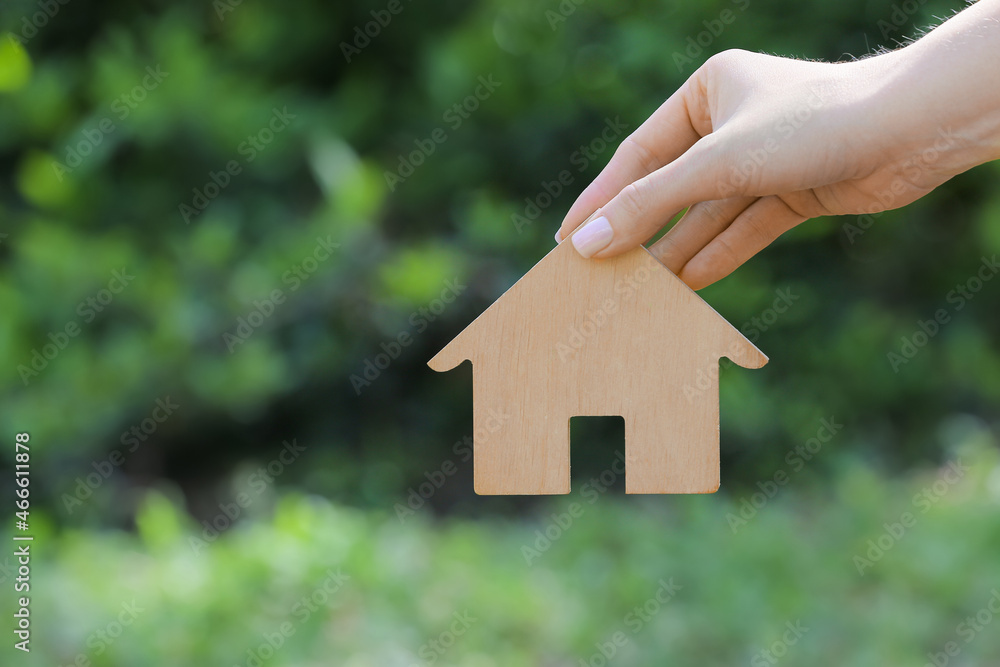 Woman with wooden house outdoors, closeup