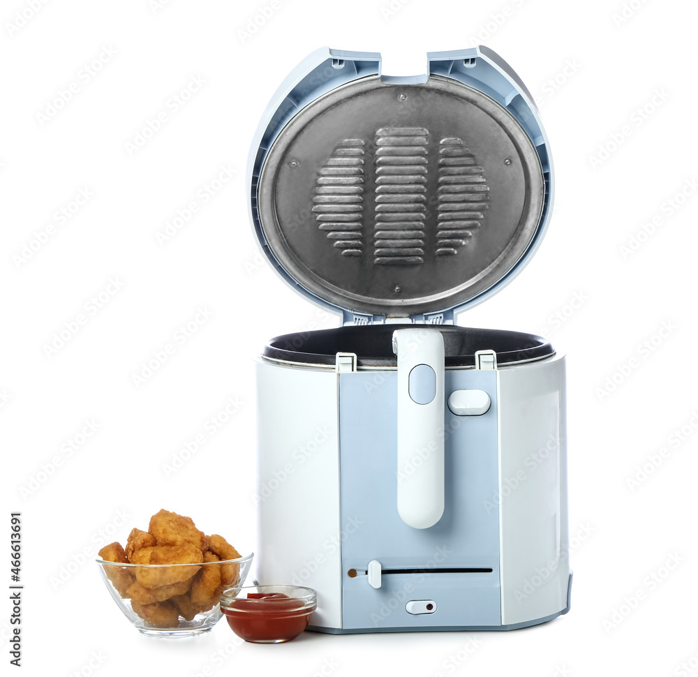 Modern deep fryer with nuggets and ketchup on white background