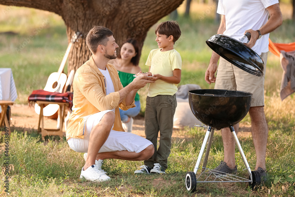 Happy family at barbecue party on summer day