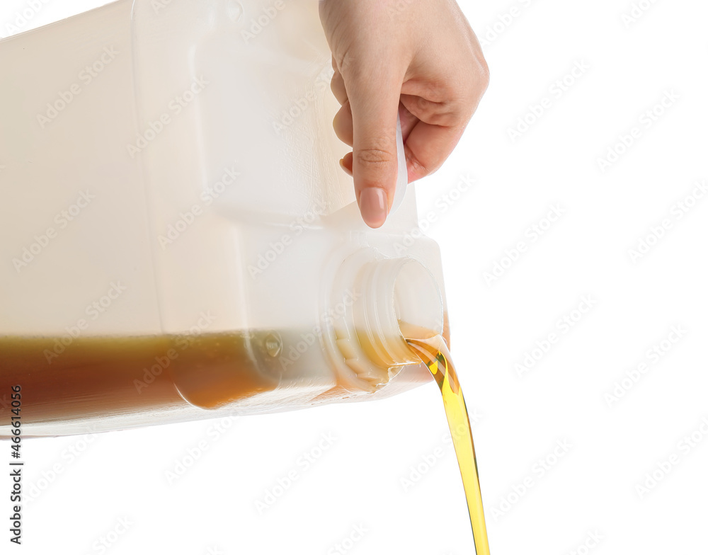 Woman pouring motor oil from canister against white background