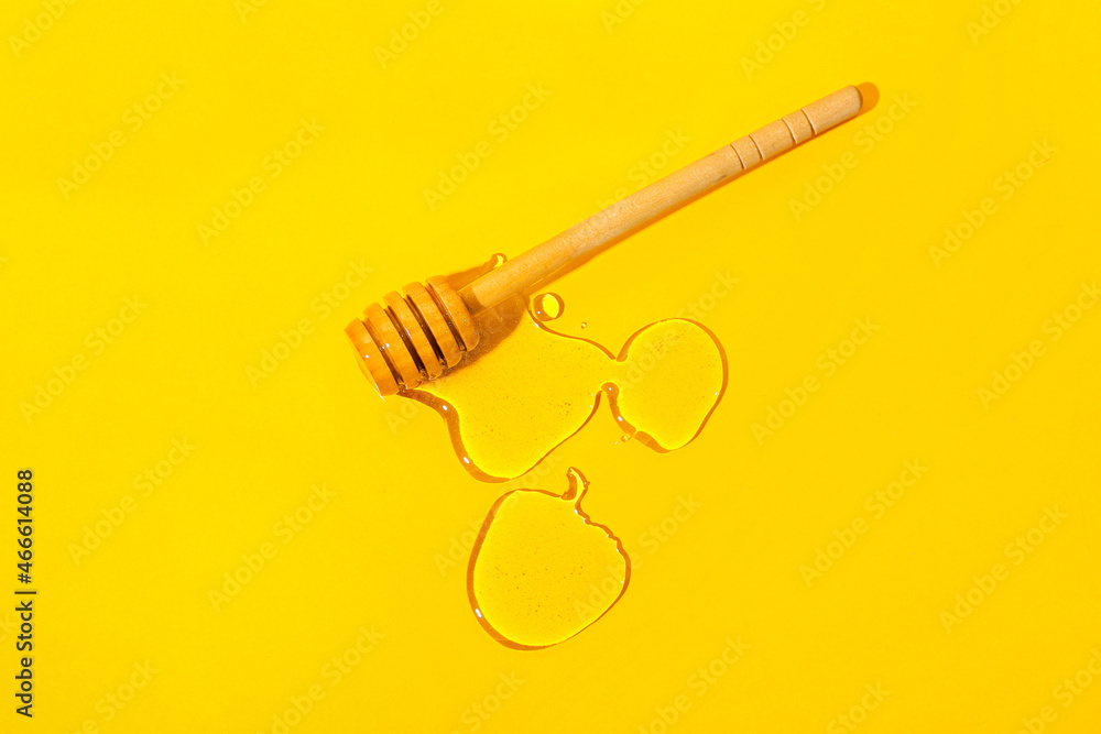 Wooden dipper with honey on color background