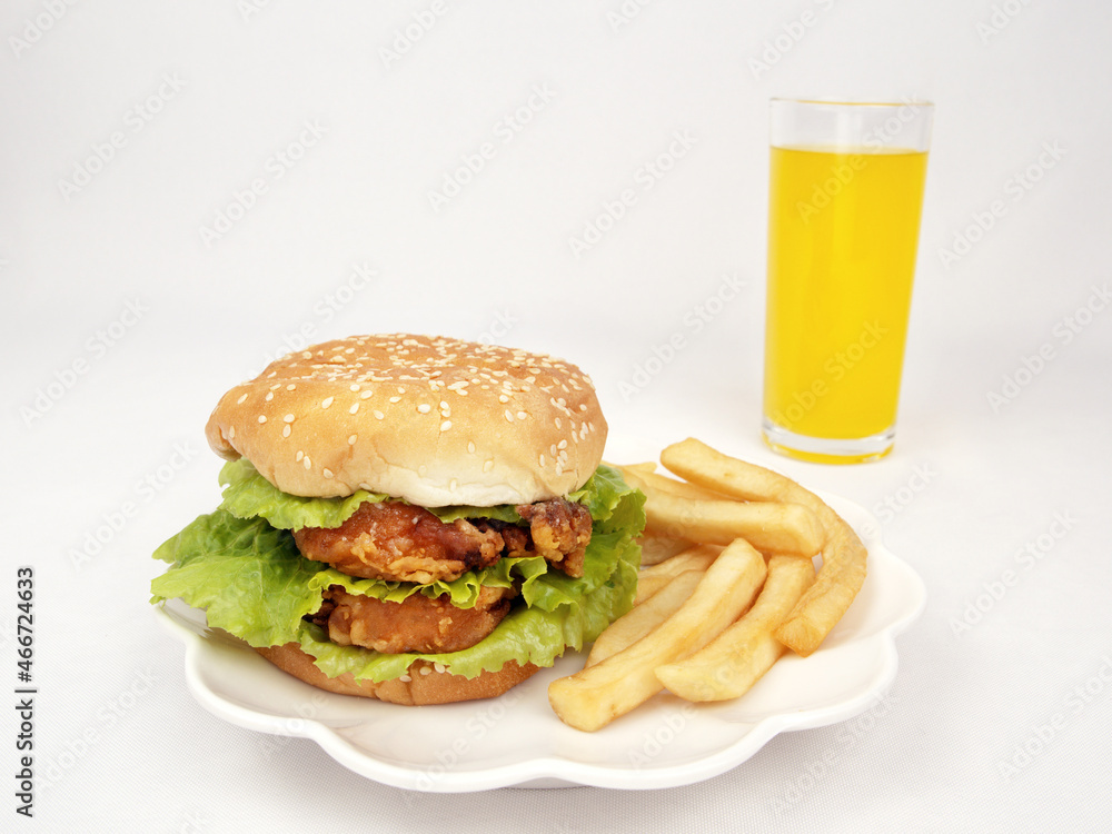 Closeup of a hamburger, french fries, orange juice; delicious fast food