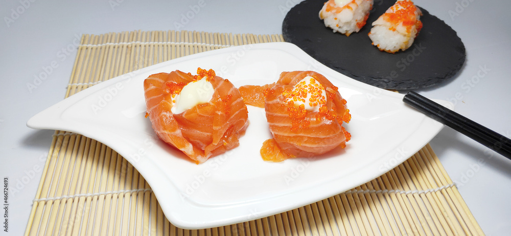 Close-up of crab roe salmon sushi rolls and chopsticks, Japanese cuisine