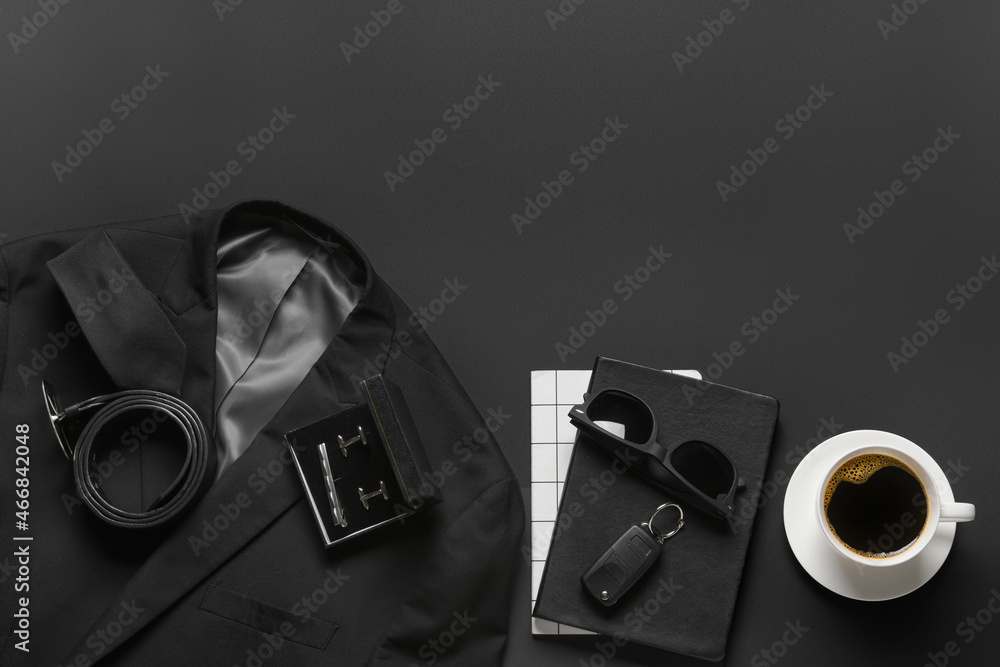 Stylish male accessories, clothes and cup of coffee on dark background